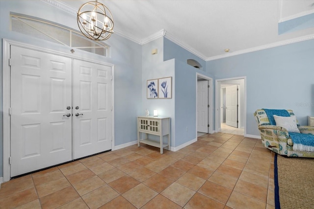 tiled entryway featuring an inviting chandelier and ornamental molding