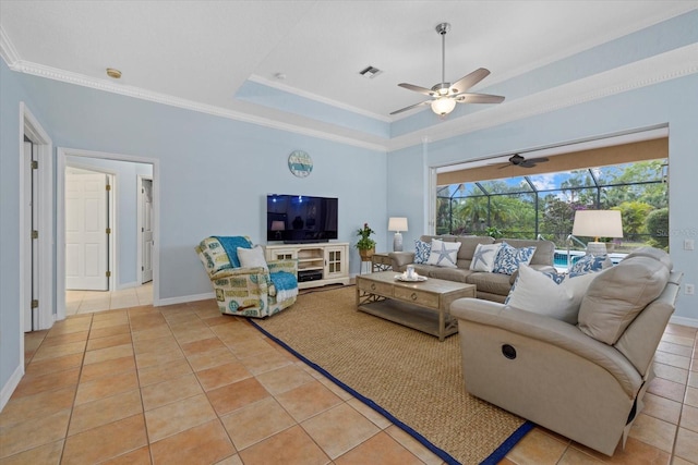 tiled living room featuring ceiling fan, crown molding, and a tray ceiling