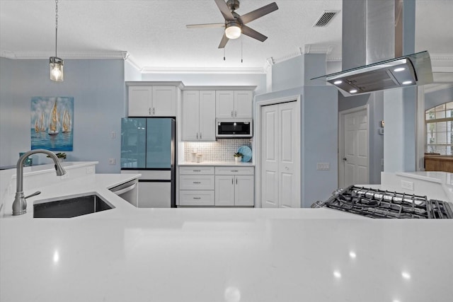 kitchen with island range hood, decorative light fixtures, stainless steel appliances, white cabinetry, and sink