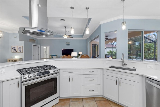 kitchen with hanging light fixtures, stainless steel appliances, island exhaust hood, ceiling fan, and sink