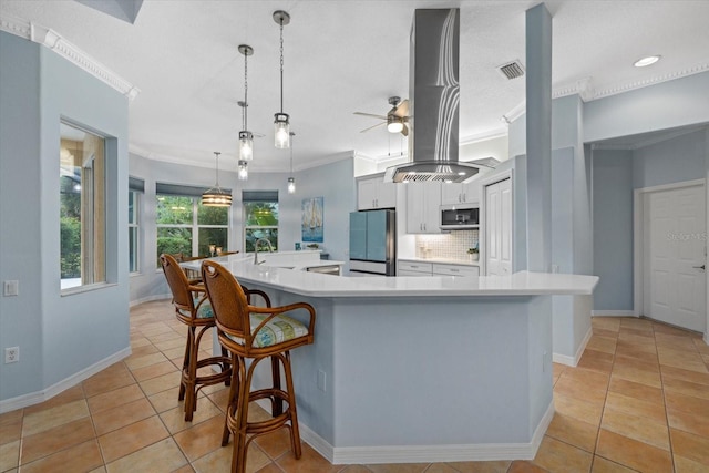 kitchen featuring hanging light fixtures, refrigerator, a large island with sink, and island range hood