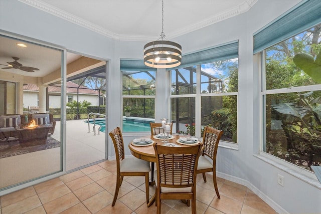 sunroom with ceiling fan with notable chandelier and a wealth of natural light