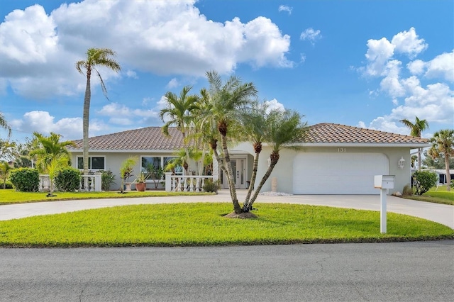 mediterranean / spanish-style house featuring a garage and a front yard