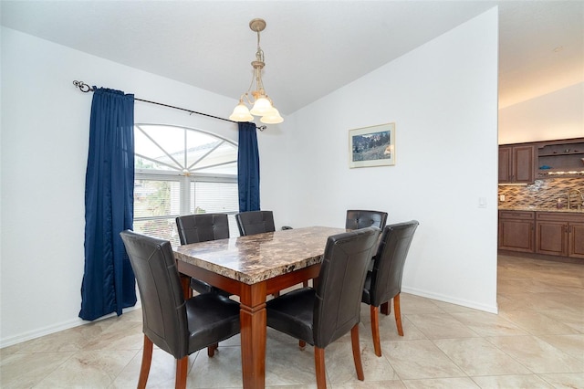 tiled dining room with a chandelier and vaulted ceiling