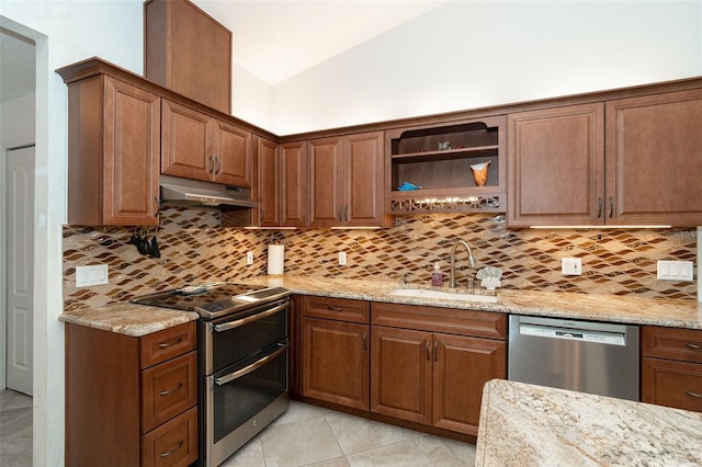 kitchen featuring backsplash, light stone countertops, sink, and stainless steel appliances