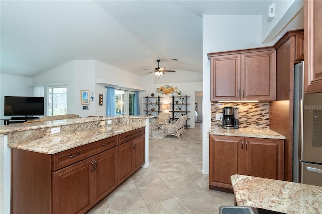 kitchen featuring light tile patterned floors, ceiling fan, tasteful backsplash, lofted ceiling, and light stone countertops