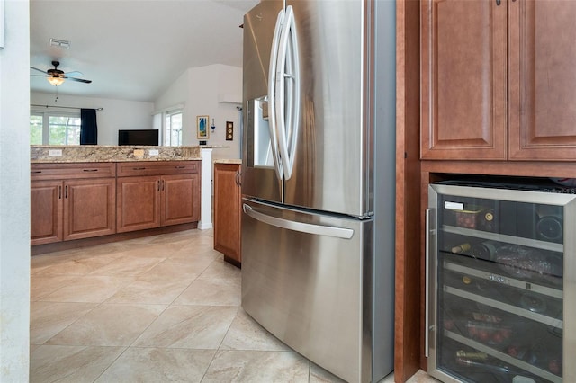 kitchen featuring stainless steel fridge, ceiling fan, wine cooler, light stone countertops, and vaulted ceiling