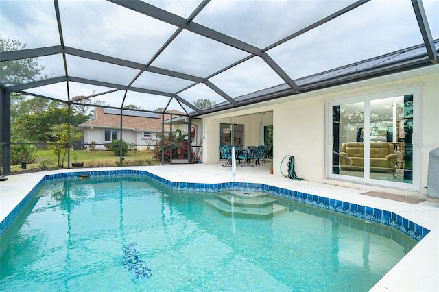 view of swimming pool featuring glass enclosure and a patio area