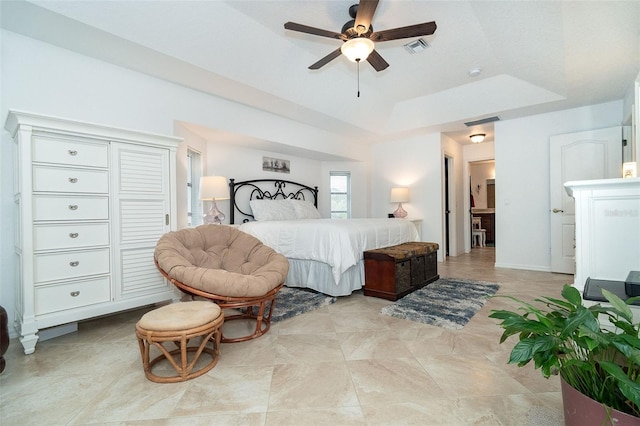 bedroom with ceiling fan and a tray ceiling