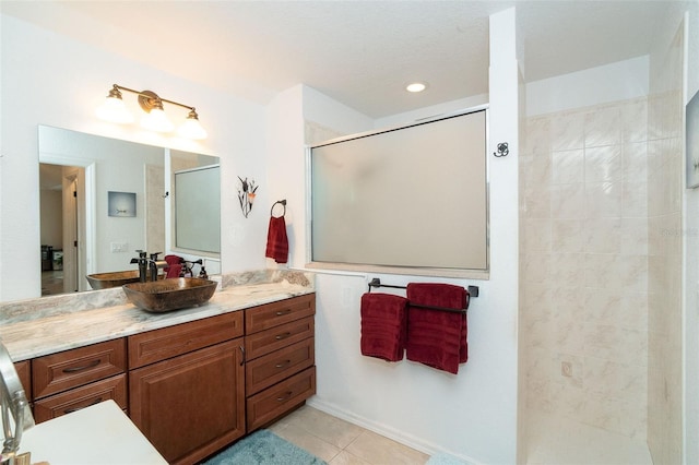 bathroom featuring tile patterned floors, vanity, and tiled shower