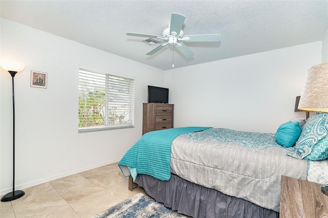 tiled bedroom featuring a textured ceiling and ceiling fan