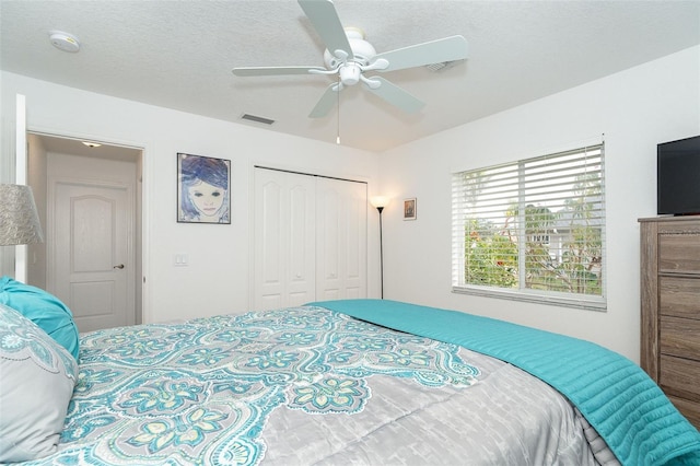 bedroom featuring a textured ceiling, a closet, and ceiling fan