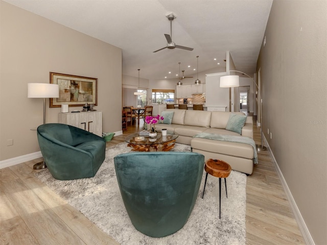 living room featuring light hardwood / wood-style floors, lofted ceiling, and ceiling fan