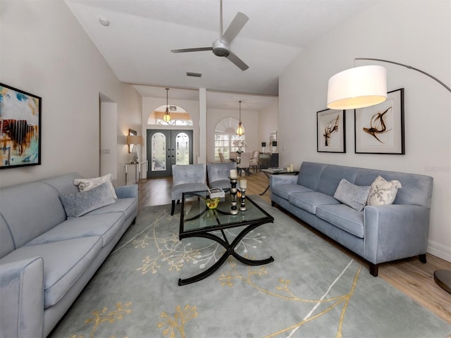 living room featuring ceiling fan, french doors, lofted ceiling, and wood-type flooring