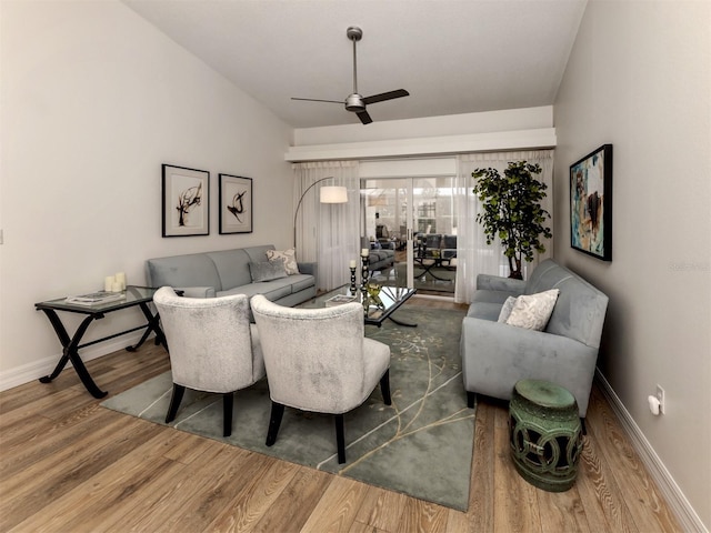 living room featuring ceiling fan, lofted ceiling, and wood-type flooring