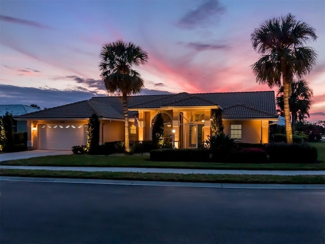 view of front of property with a yard and a garage