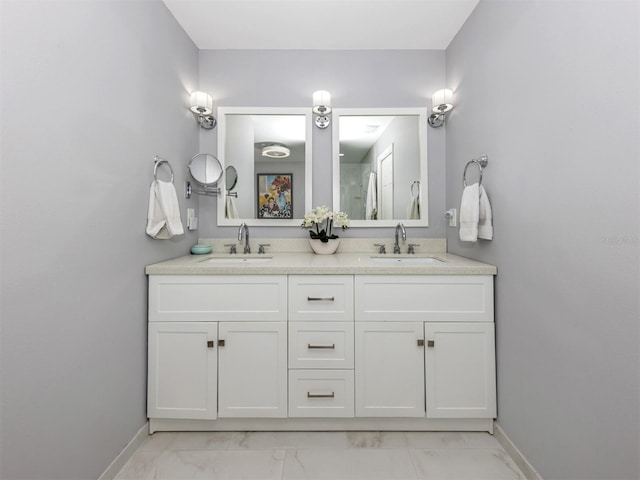 bathroom with marble finish floor, baseboards, and a sink