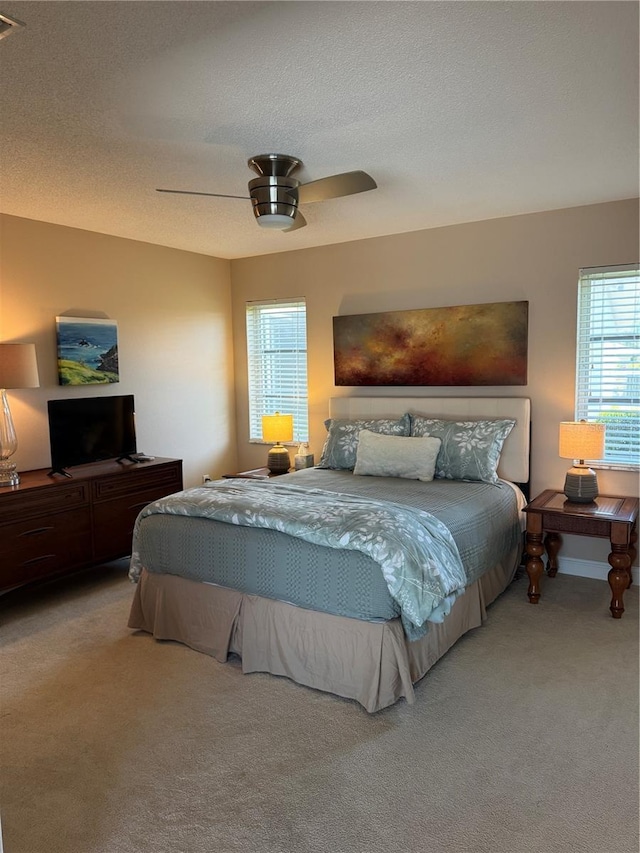 bedroom featuring ceiling fan, a textured ceiling, and carpet