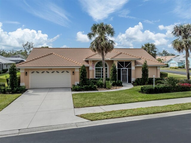 view of front of house featuring stucco siding, a tile roof, driveway, a front yard, and a garage