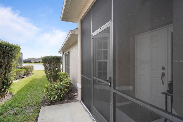 view of exterior entry with a lawn