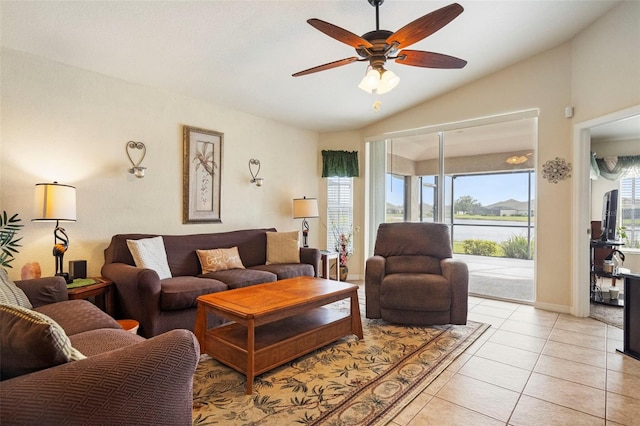 tiled living room with vaulted ceiling, a healthy amount of sunlight, and ceiling fan