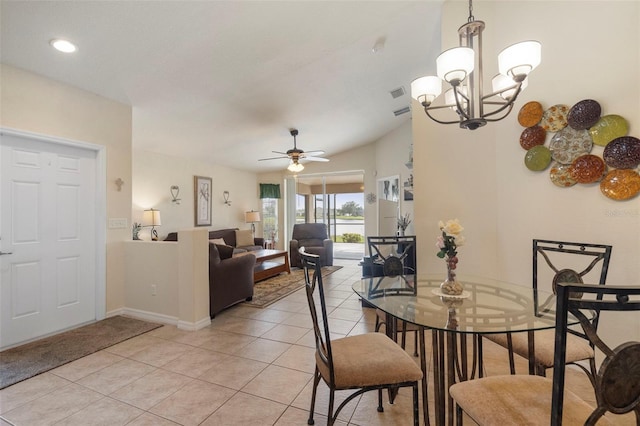 tiled dining room with ceiling fan with notable chandelier