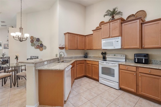 kitchen featuring pendant lighting, sink, light tile patterned floors, kitchen peninsula, and white appliances