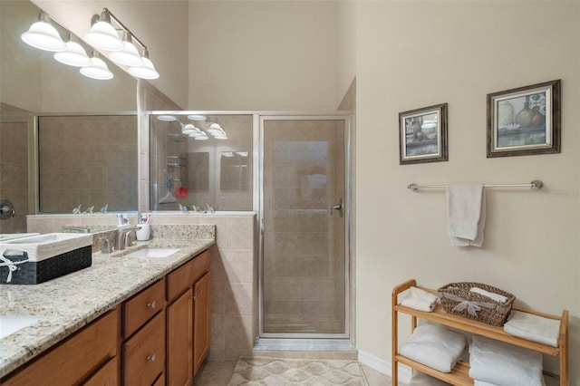 bathroom with tile patterned flooring, vanity, and a shower with door