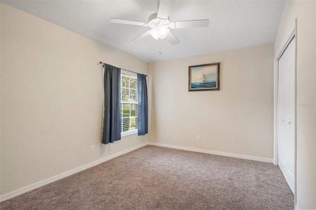 carpeted spare room featuring ceiling fan