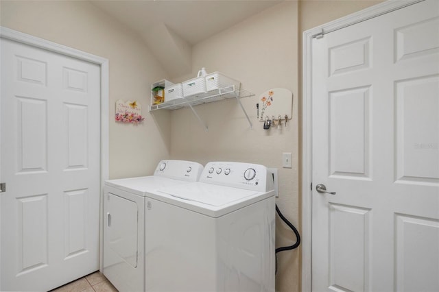 clothes washing area featuring light tile patterned flooring and separate washer and dryer