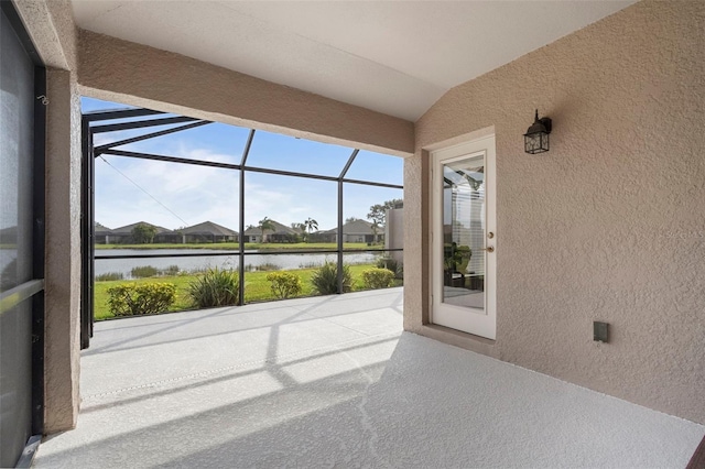 unfurnished sunroom with a water view, a healthy amount of sunlight, and lofted ceiling