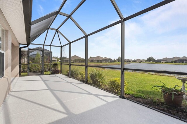 unfurnished sunroom featuring a water view