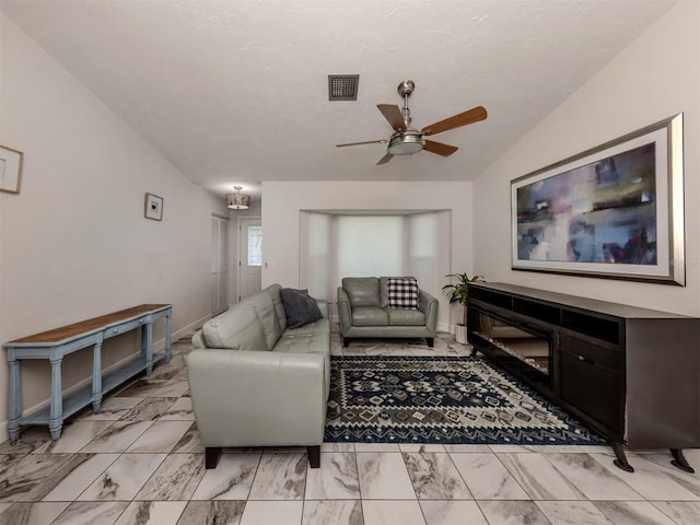 living room featuring lofted ceiling, a textured ceiling, and ceiling fan