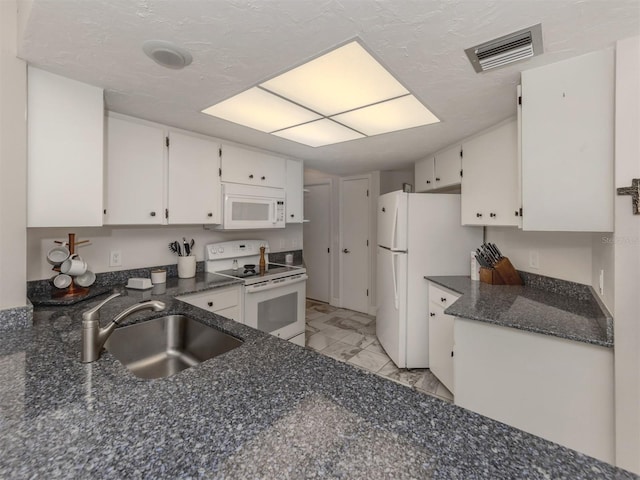 kitchen with white cabinetry, sink, a textured ceiling, and white appliances