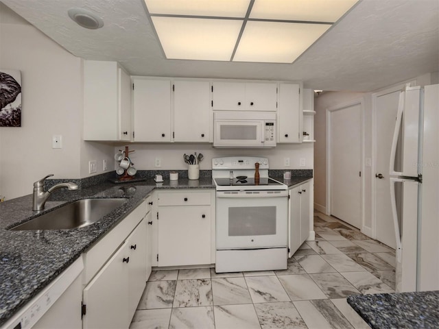 kitchen with white cabinetry, white appliances, dark stone counters, and sink