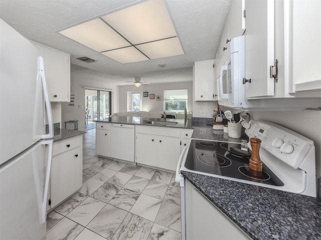 kitchen featuring white cabinetry, sink, white appliances, and kitchen peninsula