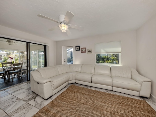 unfurnished living room featuring a wealth of natural light and ceiling fan