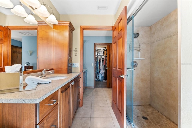 bathroom featuring vanity, a shower with shower door, and tile patterned floors