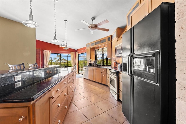 kitchen featuring hanging light fixtures, appliances with stainless steel finishes, light tile patterned floors, and ceiling fan