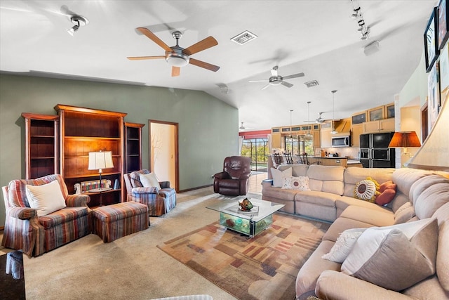 living room featuring light colored carpet, track lighting, and vaulted ceiling