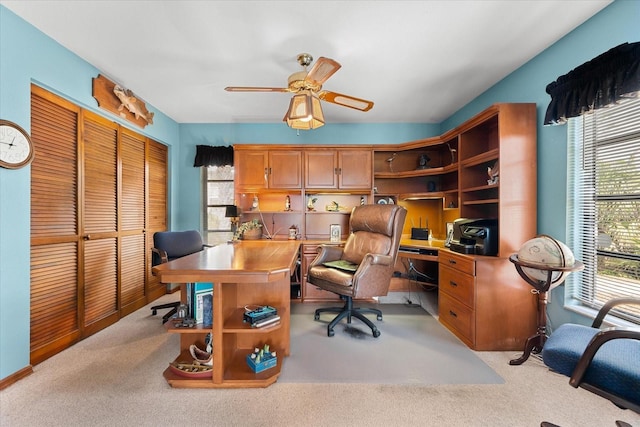 home office with light carpet and ceiling fan