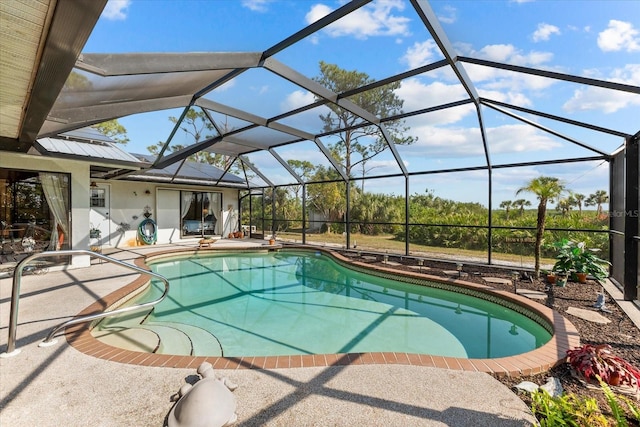 view of pool with a patio and glass enclosure