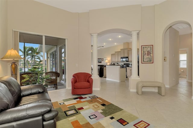 tiled living room with a high ceiling and ornate columns