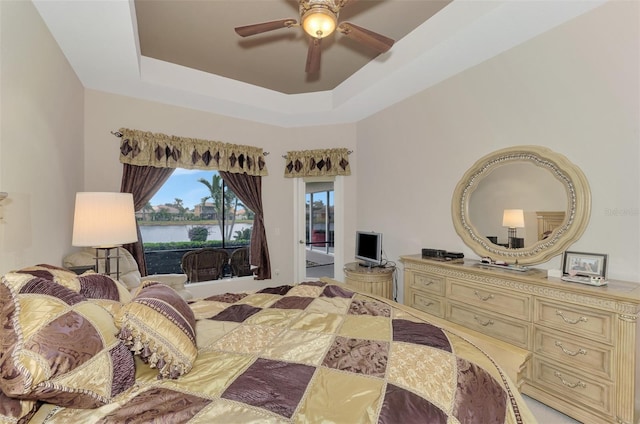 bedroom with ceiling fan and a raised ceiling