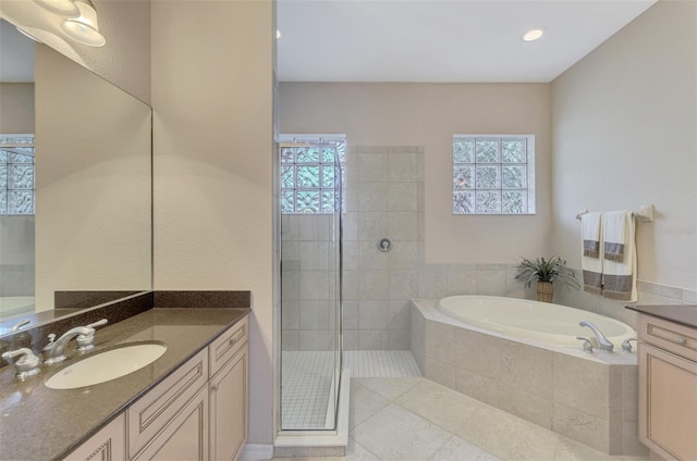 bathroom featuring vanity, separate shower and tub, and a healthy amount of sunlight