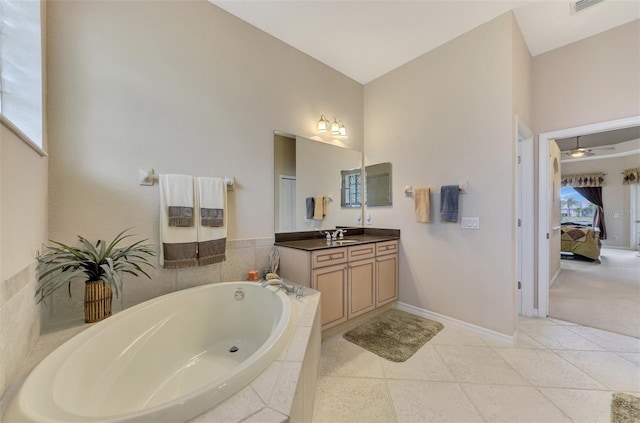 bathroom featuring tiled tub, vanity, and tile patterned floors