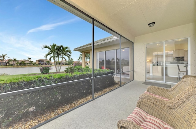 sunroom featuring a water view