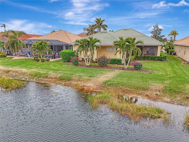 view of front of home featuring a front yard, a water view, and glass enclosure