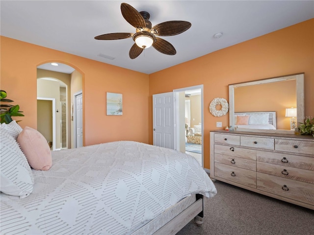 carpeted bedroom featuring connected bathroom and ceiling fan