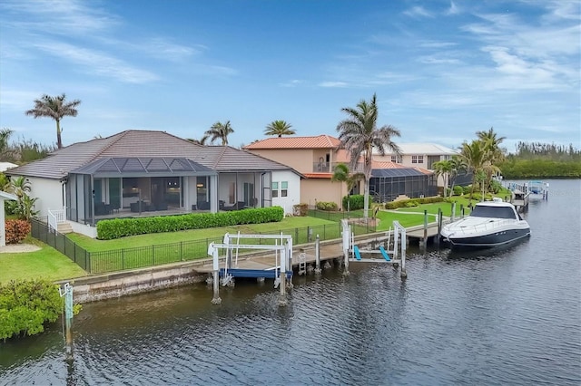 exterior space with glass enclosure, a water view, and a yard